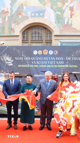 Nguyên Phó Thủ tướng Thường trực Chính phủ Nguyễn Hòa Bình, Đại sứ Dương Hoài Nam cùng quan chức thành phố Karlovy Vary cắt băng khai mạc “Ngày hội quảng bá Văn hóa-Ẩm thực-Áo dài Việt Nam.” (Ảnh: Việt Thắng/TTXVN)