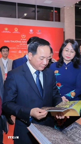 Trưởng Ban Tuyên giáo và Dân vận Trung ương Trịnh Văn Quyết cùng các đại biểu tham quan khu trưng bày sách đoạt giải. (Ảnh: Phan Phương/TTXVN)