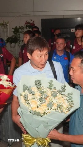 Ban lãnh đạo đội tuyển nhận hoa chúc mừng của các cổ động viên. (Ảnh: Trung Tuyến/TTXVN)