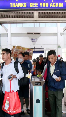 Hành khách qua cửa soát vé để vào sân ga lên tàu. (Ảnh: Tiến Lực/TTXVN)