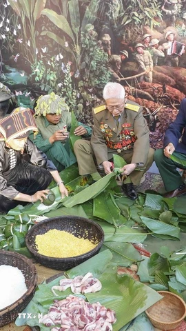 Các cựu chiến binh Điện Biên cùng cán bộ, chiến sỹ trẻ tham gia gói bánh, tái hiện sinh hoạt Tết của bộ đội giữa núi rừng Tây Bắc. (Ảnh: Xuân Tư/TTXVN)