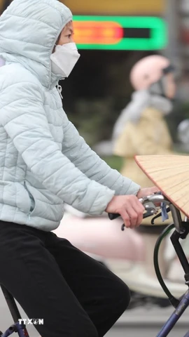 Người dân Thủ đô trang bị áo chống rét khi tham gia giao thông. (Ảnh: Thanh Tùng/TTXVN)