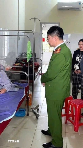 Đại tá Ma Quang Trung, Phó Giám đốc Công an tỉnh Tuyên Quang, thăm hỏi, động viên Thiếu tá Nguyễn Văn Đông, cán bộ Cảnh sát giao thông bị thương khi làm nhiệm vụ, đang điều trị tại Trung tâm y tế khu vực Hàm Yên. (Ảnh: TTXVN phát)