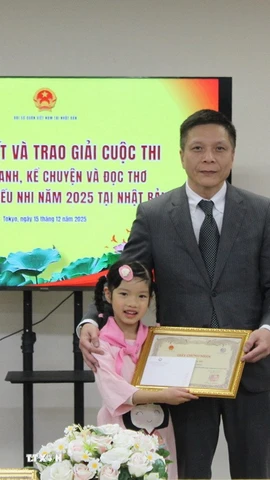 Bé Kim Trà My nhận Giấy khen từ lãnh đạo Đại sứ quán Việt Nam tại Nhật Bản. (Ảnh: Phạm Tuân/TTXVN)