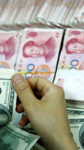 Nhân viên kiểm đồng USD và đồng nhân dân tệ. (Ảnh: AFP/TTXVN)