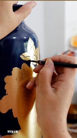 Vẽ hoa văn trên sản phẩm gốm sứ tại làng nghề Hạ Thái. (Ảnh: Trần Việt/TTXVN)