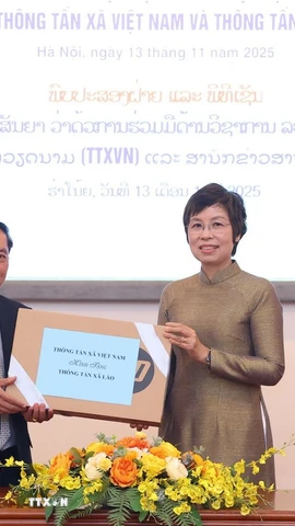 Tổng giám đốc Thông tấn xã Việt Nam Vũ Việt Trang trao tặng phẩm tặng Thông tấn xã Pathet Lào. (Ảnh: Văn Điệp/TTXVN)