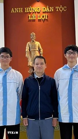 Thầy giáo Bùi Văn Bình, giáo viên môn Toán Trường THPT chuyên Lam Sơn chụp ảnh cùng Phúc Khánh (bên trái) và Vĩnh Kỳ. (Ảnh: TTXVN phát)