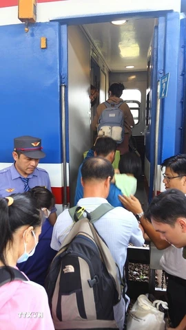 Hành khách xếp hàng lên tàu. (Ảnh: Lê Xuân/TTXVN)