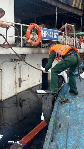 Trong quá trình bốc dỡ hàng hóa, do sơ suất khi vận hành cần cẩu, dây cáp bị tuột khiến cọc bê tông rơi xuống làm thủng đáy tàu, nước tràn vào khoang gây ngập tàu. (Ảnh: TTXVN phát)