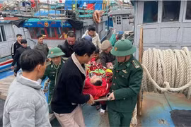 Cán bộ, chiến sỹ Đồn Biên phòng Quỳnh Phương và ngư dân vận chuyển nạn nhân lên tuyến trên điều trị. (Nguồn: Báo Nhân dân)