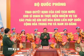 Thượng tướng Hoàng Xuân Chiến, Thứ trưởng Bộ Quốc phòng trao Quyết định của Chủ tịch nước cho các sỹ quan. (Ảnh: Trọng Đức/TTXVN)