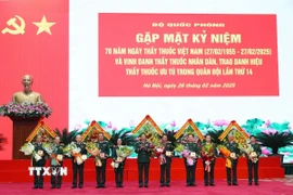 Đại tướng Phan Văn Giang trao Kỷ niệm chương và tặng hoa chúc mừng các Thầy thuốc Nhân dân. (Ảnh: Hồng Pha/TTXVN phát)