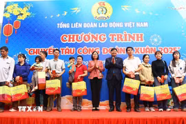 Trao tặng vé tàu khứ hồi và quà cho công nhân về quê đón Tết. (Ảnh: Đức Hạnh/TTXVN)