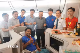 Lãnh đạo VFF, Ban huấn luyện đội tuyển và tiền đạo Xuân Son chụp ảnh chung khi máy bay vừa hạ cánh. (Ảnh: Minh Quyết/TTXVN)
