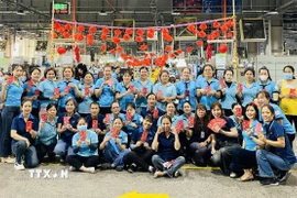 Lì xì công nhân Công ty Chang Shin Việt Nam trong ngày làm việc đầu tiên sau kỳ nghỉ Tết. (Ảnh: TTXVN phát)