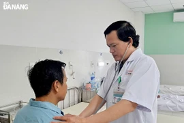 Bác sỹ Thân Trọng Vũ, Trưởng Khoa Ngoại lồng ngực (bên phải) kiểm tra sức khỏe cho bệnh nhân N.T.K trước khi làm thủ tục xuất viện. (Nguồn: báo Đà Nẵng)