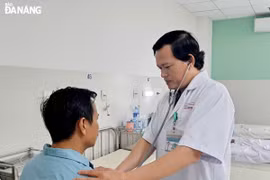 Bác sỹ Thân Trọng Vũ, Trưởng Khoa Ngoại lồng ngực (bên phải) kiểm tra sức khỏe cho bệnh nhân N.T.K trước khi làm thủ tục xuất viện. (Nguồn: báo Đà Nẵng)
