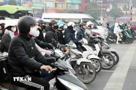 Người dân chấp hành hiệu lệnh đèn tín hiệu giao thông tại tuyến đường Khuất Duy Tiến-Nguyễn Trãi, Hà Nội. (Ảnh: Phạm Kiên/TTXVN)