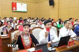 Đại biểu HĐND tỉnh Yên Bái biểu quyết thông qua Nghị quyết tại Kỳ họp. (Ảnh: TTXVN phát)
