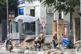 Công nhân xây dựng đang gấp rút hoàn thành vỉa hè. (Ảnh: Hoàng Hiếu/TTXVN)