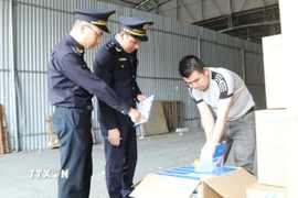 Cán bộ Đội Hải quan cửa khẩu Chi Ma kiểm soát hàng hóa tại kho bãi khu vực cửa khẩu Chi Ma. (Ảnh: Quang Duy /TTXVN)