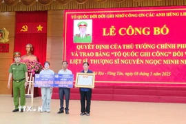 Thượng tá Trần Thanh Hiển, Phó Giám đốc Công an tỉnh Bà Rịa-Vũng Tàu trao Bằng Tổ quốc ghi công và kinh phí hỗ trợ cho thân nhân Liệt sỹ, Thượng sỹ Nguyễn Ngọc Minh Nhật. (Ảnh: Đoàn Mạnh Dương/TTXVN)