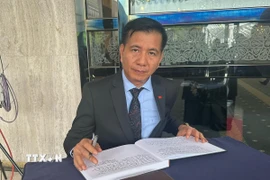 Đại sứ Đinh Ngọc Linh viết sổ tang tại lễ viếng cố Thủ tướng Abdullah bin Ahmad Badawi. (Ảnh: Hằng Linh/TTXVN)