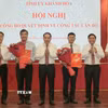Thường trực Tỉnh ủy Khánh Hòa trao quyết định và tặng hoa chúc mừng ông Tạ Hồng Quang (bên trái) và nhà báo Lê Hoàng Triều (bên phải). (Ảnh: Xuân Triệu/TTXVN)