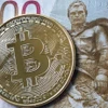 Đồng tiền ruble của Nga và đồng tiền kỹ thuật số Bitcoin. (Ảnh: Getty Images/TTXVN)