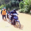 Hỗ trợ người dân ra khỏi vùng ngập lụt tại xã Mường Hung. (Ảnh: Quang Quyết/TTXVN)