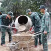 Các chiến sỹ Trung đoàn 974 khẩn trương làm việc tại công trình nhà ở sau lũ hộ ông Hà Quyn, thôn Đá Trắng, xã Nam Khánh Vĩnh. (Ảnh: Phan Sáu/TTXVN)
