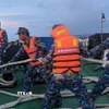 Các chiến sĩ giúp một tàu ngư dân bị nạn. (Ảnh: TTXVN phát)