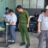 Cơ quan chức năng thu mẫu nước thải của bệnh viện S.I.S để kiểm tra. (Ảnh: TTXVN phát)