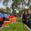 Các đại biểu thực hiện nghi thức đưa hài cốt liệt sỹ đến nơi an nghỉ. (Ảnh: Nhựt An/TTXVN) 