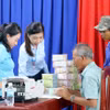 Người dân vùng dự án Nhà máy điện hạt nhân Ninh Thuận 2 (ở xã Vĩnh Hải) nhận tiền bồi thường đất tại trụ sở Ủy ban Nhân dân xã. (Ảnh: Công Thử/TTXVN)