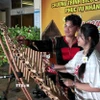 Sinh viên Việt Nam ở nước ngoài trải nghiệm nhạc cụ đàn T'rưng. (Ảnh: Tường Quân/TTXVN)