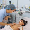 Nhân viên y tế Bệnh viện Nhi đồng 1 Thành phố Hồ Chí Minh chăm sóc bệnh nhi mắc tay chân miệng. (Ảnh: Đinh Hằng/TTXVN)