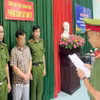 Lực lượng chức năng đọc quyết định khởi tố bị can đối với ông H.V.P. (Ảnh: TTXVN phát) 
