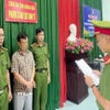 Lực lượng chức năng đọc quyết định khởi tố bị can đối với ông H.V.P. (Ảnh: TTXVN phát) 