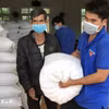 Người dân nhận gạo hỗ trợ của Chính phủ. (Ảnh: Hưng Thịnh/TTXVN)