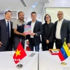 Trưởng Cơ quan thường trú TTXVN tại Mexico Trương Phi Hùng tặng quà lưu niệm cho Thứ trưởng Bộ Thông tin Truyền thông Venezuela Simón Arrechide. (Ảnh: AVN/TTXVN phát) 