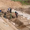 Một thuyền (đậy bạt) và thuyền bên cạnh được cố định với nhau bằng thanh gỗ, các nhà khảo cổ học cho rằng thuyền có kết cấu độc đáo, lần đầu tiên được phát hiện. (Ảnh: Thái Hùng/TTXVN)