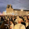 Hàng chục nghìn người tới tập trung tại vườn hoa Tuileries và bảo tàng Louvre để chứng kiến Ngọn lửa Olympic. (Ảnh: Ngọc Hiệp/TTXVN)