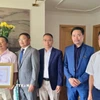 Tham tán Công xứ Chu Tuấn Đức (đứng giữa), Chủ tịch Hội Cựu chiến binh Việt Nam tại Cộng hòa Liên bang Đức trao giấy khen, tri ân công lao của gia đình ông Lê Đình Bính (đứng đầu) có người thân là liệt sỹ. (Ảnh: Phương Hoa/TTXVN)