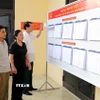 Người dân theo dõi danh sách cử tri tại Khu vực bỏ phiếu số 1, xã Gia Viễn, tỉnh Ninh Bình. (Ảnh: Thùy Dung/TTXVN)