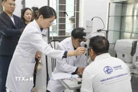 Các bác sỹ Đoàn Y tế tỉnh Vân Nam, Trung Quốc thăm khám cho bệnh nhân trước khi phẫu thuật. (Ảnh: Xuân Tư/TTXVN)