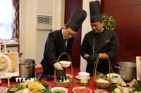 Quan chức ngoại giao tại Trung Quốc trải nghiệm cách chế biến một tô phở. (Ảnh: Hải Yến/TTXVN)