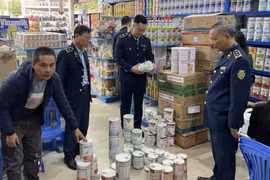 Lực lượng chức năng kiểm tra mặt hàng sữa. (Ảnh: PV/Vietnam+)