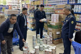 Lực lượng chức năng kiểm tra mặt hàng sữa. (Ảnh: PV/Vietnam+)